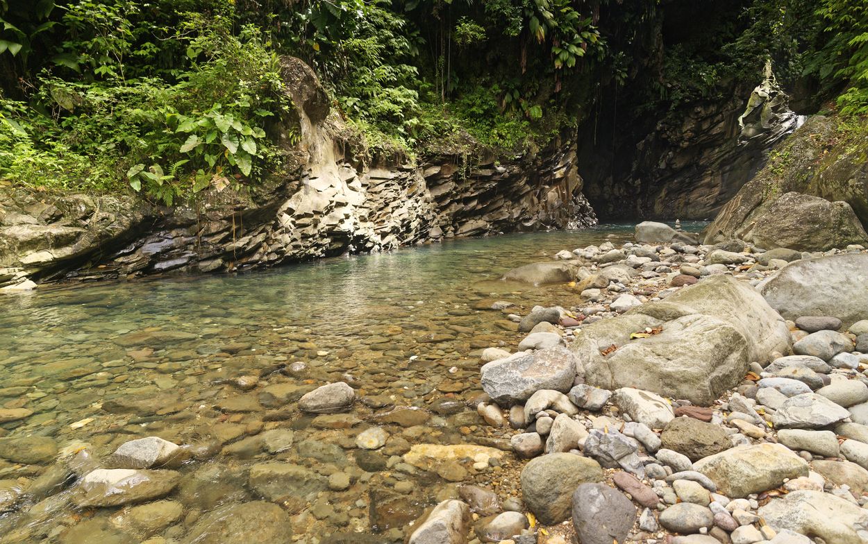 Seitenansicht des Matouba-Wasserfalls Ruhiger Fluss mit bunten Kieselsteinen
