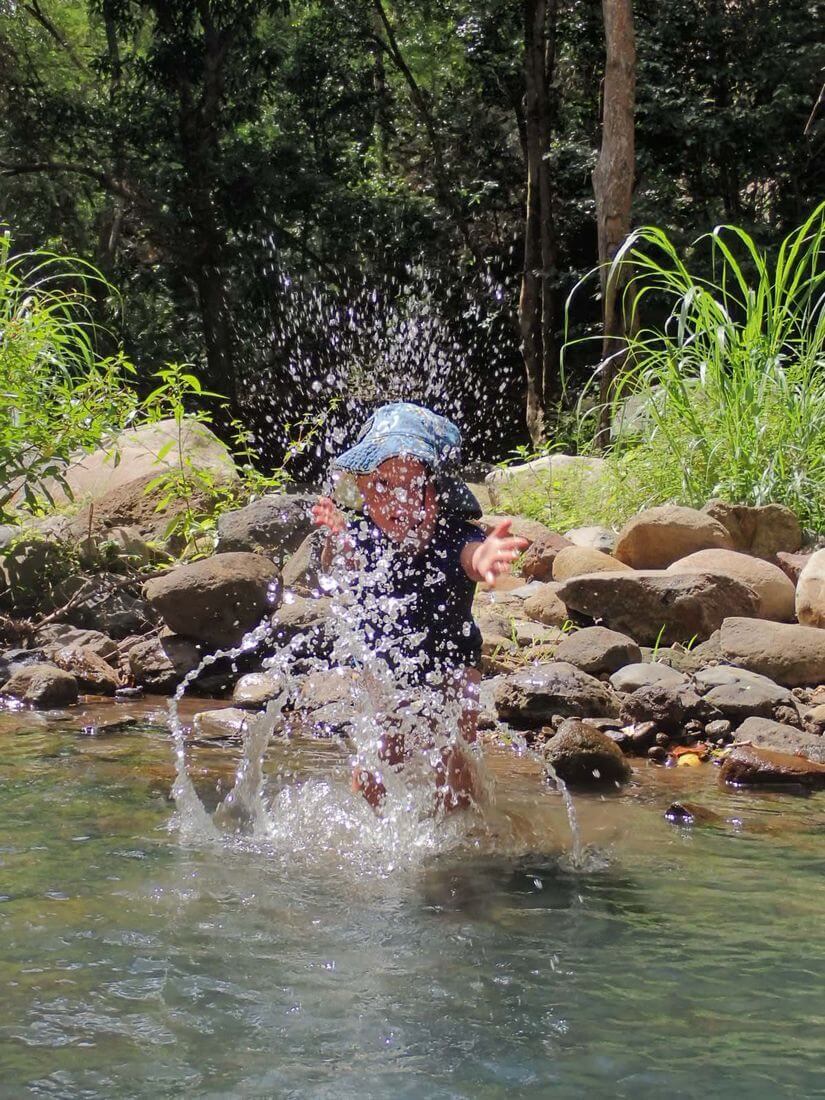 Niños y naturaleza Niño jugando felizmente, cascada Kalinago, Guadalupe
