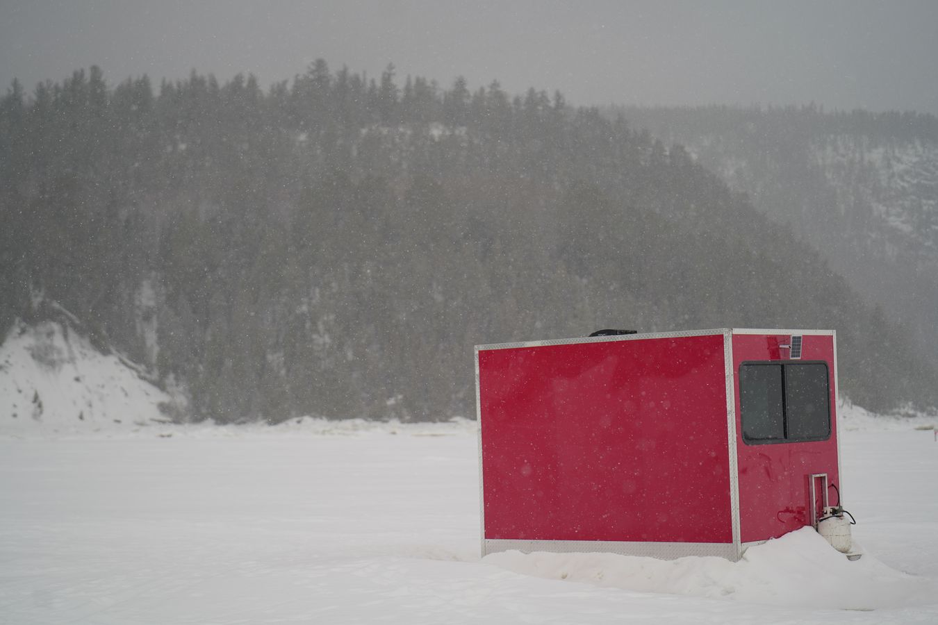 cabaña roja sobre el hielo nuestra cabaña por el día
